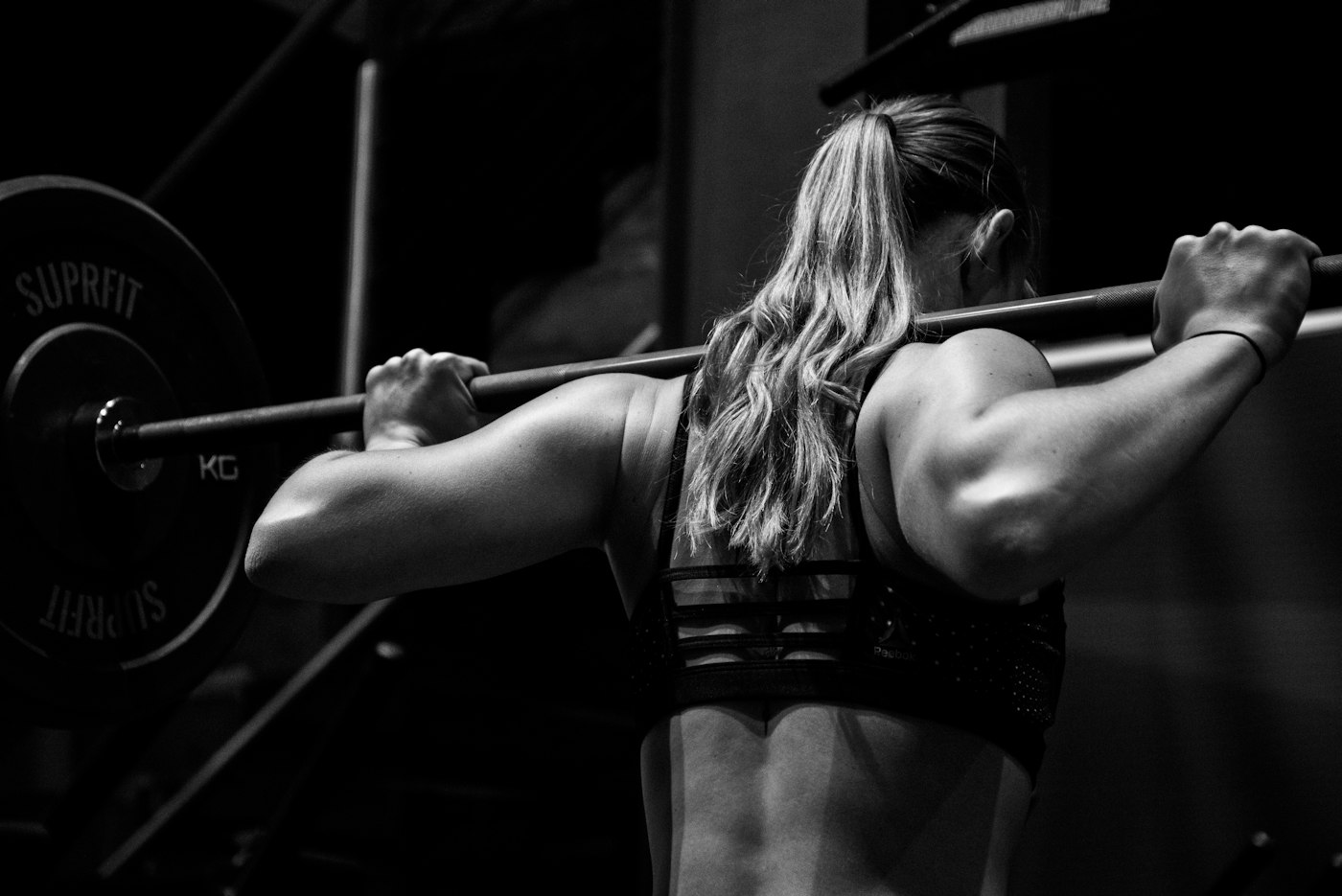 Athlete holding a barbell on her back before a squat